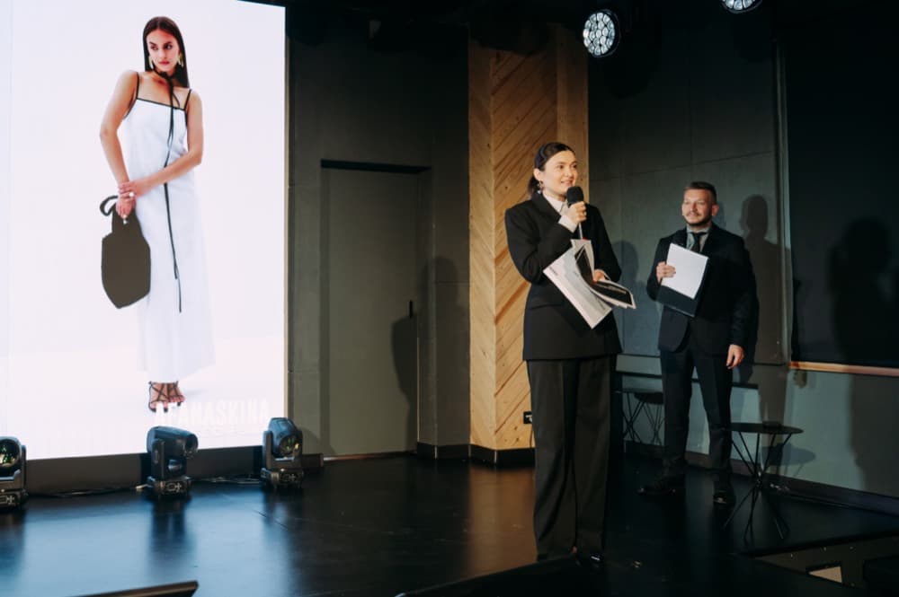 Татьяна Афанаскина выступает на сцене фестиваля, на экране — лукбук AFANASKINA